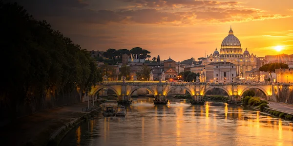 Rome skyline at sunset with St. Peter's Basilica and Ponte Sant'Angelo over the Tiber River