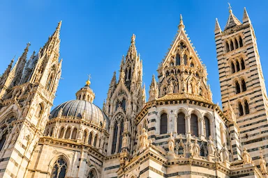 Siena Cathedral and bell tower under a clear blue sky