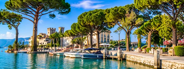 Sirmione lakeside promenade with boats and Scaliger Castle